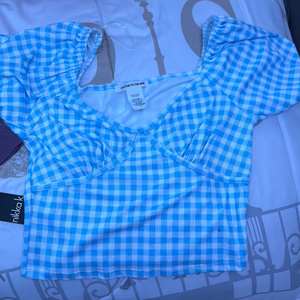 It is a white and light blue checkered top